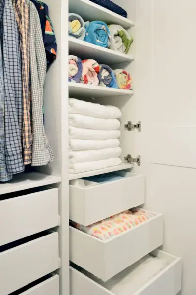 Armazenamento de toalhas de linho em prateleiras e gavetas no guarda-roupa Ikea Pax