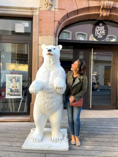 Sherry poserer med en isbjørnstatue med grønn jakke og svart tank og jeans