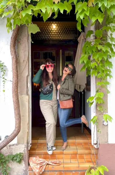 Sherry et Elsie Larson posant devant une porte avec une veste verte sur un débardeur blanc