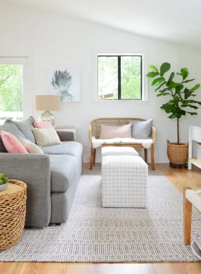 Salle familiale avec canapé, poufs rayés et banc tissé