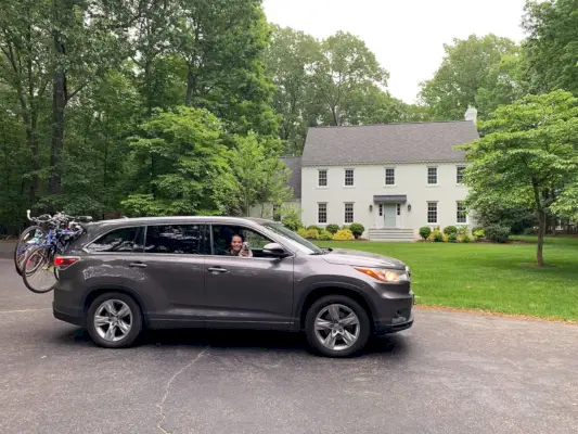 Voiture Toyota Highlander garée devant une maison en brique blanche