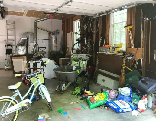 Stökigt garage med cykelmöbler och slumpmässiga utomhusförnödenheter