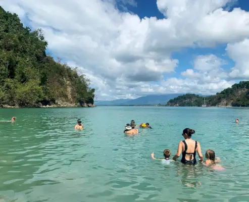 Plaža Kostarike z otroki in šerijem v vodi