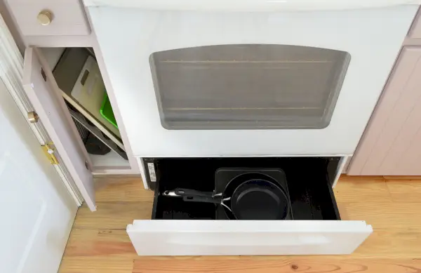 Avant Photo d'un tiroir étroit avec rangement dans un tiroir chauffant pour cuisinière