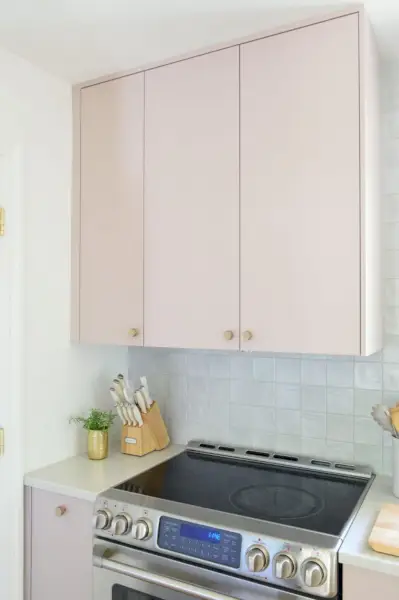 Armoire supérieure dans une cuisine Ikea peinte avec hotte Omsinnad cachée au-dessus de la cuisinière