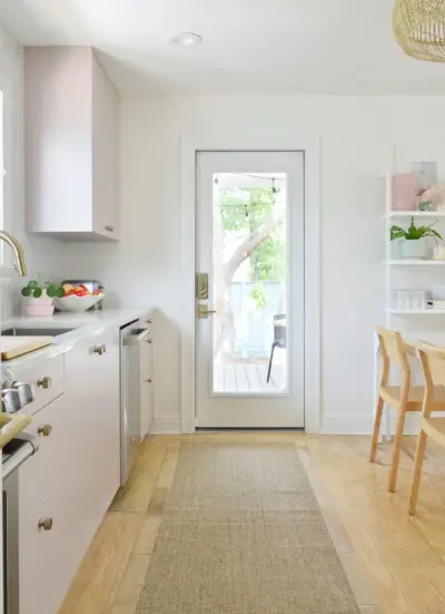 Vista para a porta da varanda da cozinha em cozinha Ikea rosa malva pintada com corredor de juta