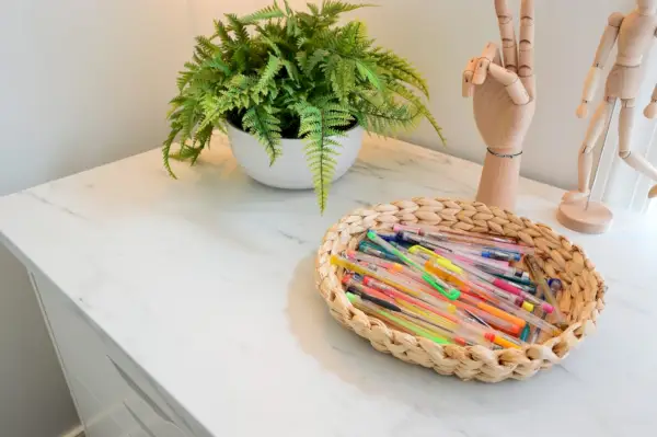 Escritorio de arte para niños con encimera laminada de mármol sintético Ikea Ekbacken con cesta de bolígrafos de gel de colores