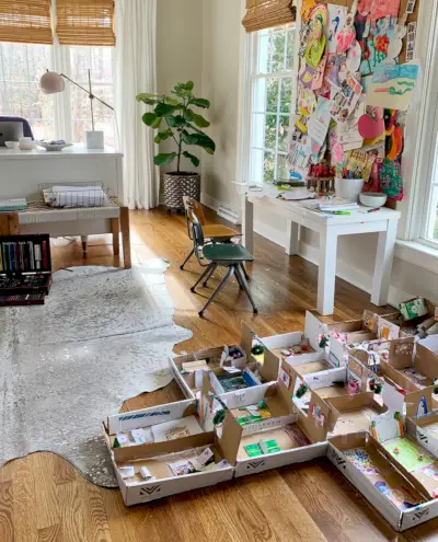 Grande création en carton au sol à côté d'un petit espace de bureau d'art dans un bureau à domicile pour adultes