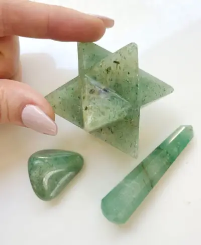 Différentes formes de cristal d'aventurine verte, dont une pierre polie d'astéroïde merkaba et une pointe polie