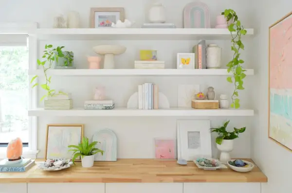 Tres estantes flotantes largos de Ikea Lack decorados con plantas, libros y cristales