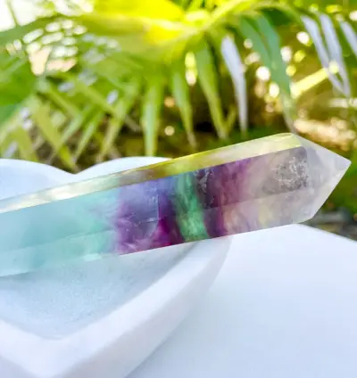 Cristal de fluorite arc-en-ciel dans un plat en pierre avec plan en arrière-plan