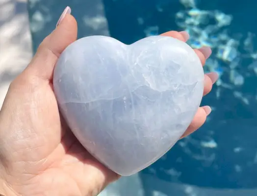 Cristal de coeur de calcite bleue sur l'eau