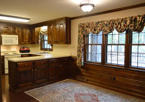 Foto anterior de una cocina de los años 80 con gabinetes de madera oscura.