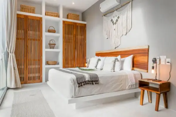 Kingsize bed in Tulum Mexico Airbnb met witte muur en houten accenten