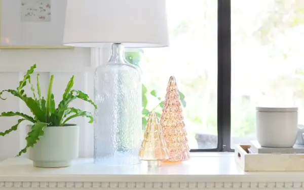 Arbres de Noël en verre éclairés sur la table d'entrée