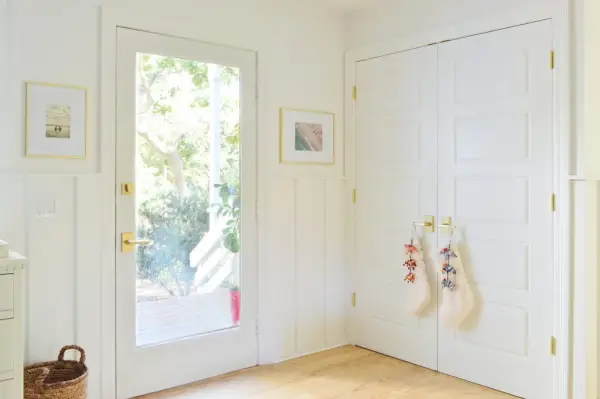 Porte d'entrée à côté du placard à linge avec bas sur la poignée