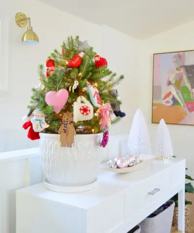 Petit arbre de table dans un pot blanc avec des ornements colorés