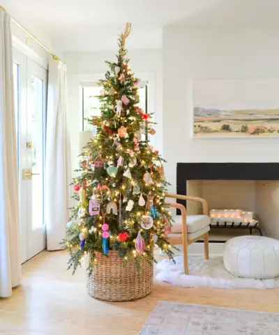 Panier tissé à la base de l'arbre de Noël avec des ornements colorés