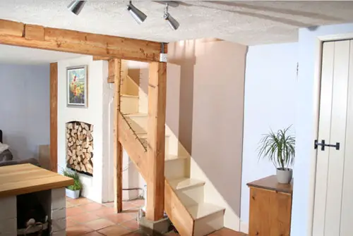 Freiliegender heller Holzbalken in einem englischen Cottage, einschließlich freiliegender Treppe