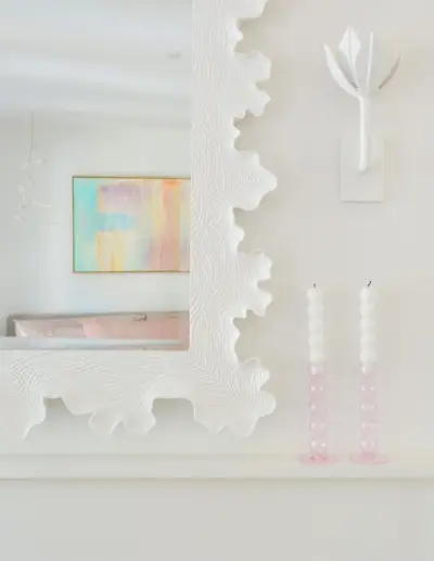 Détail du miroir festonné sculptural blanc au-dessus de la cheminée