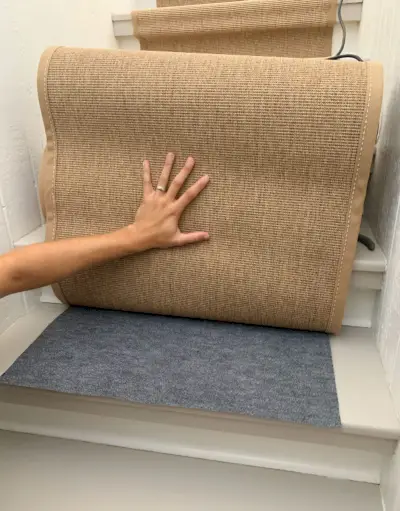 Morceau coupé de tapis en mousse placé sous le tapis d'escalier en sisal