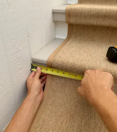 Ruban à mesurer vérifiant l'emplacement du tapis d'escalier en sisal