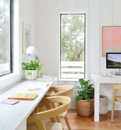 Kinderschreibtisch unter dem Fenster mit Computerarbeitsplatz im Hintergrund