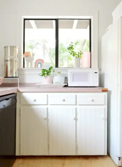 Avant la photo de boutons d'armoire en bois peint sur des armoires de cuisine