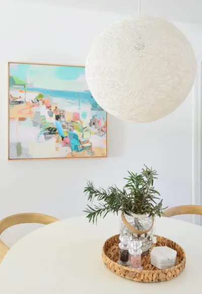 Grande suspension globe à cordes sur table blanche avec art de plage en arrière-plan