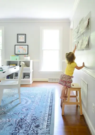 Kinderhausaufgabenzimmer mit Kind auf Hocker