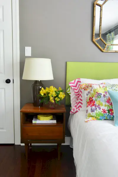 Table d'appoint dans la chambre avec fleurs colorées et tête de lit