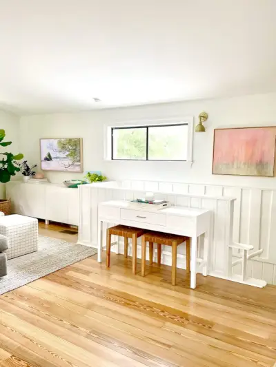 Table console par escalier dans la salle familiale moderne à l'étage avec lambris lambrissés blancs