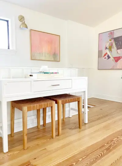 Table console dans la salle familiale moderne à l'étage avec des bancs en cuir et des œuvres d'art encadrées en arrière-plan