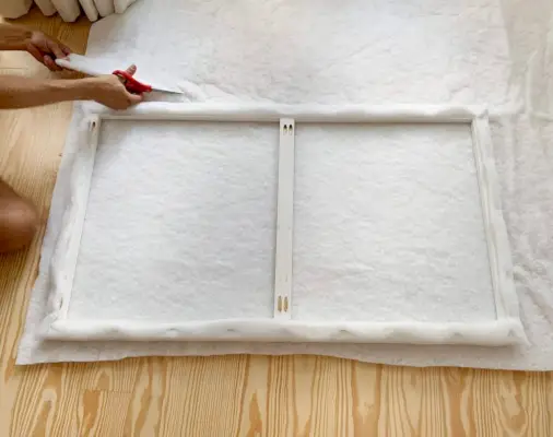 Couper la deuxième couche de molleton en tissu pour la fixer à la tête de lit rembourrée DIY