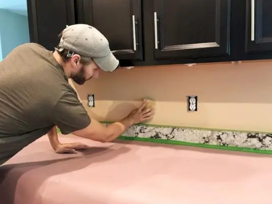 John lixando parede backsplash em preparação para instalação de azulejos