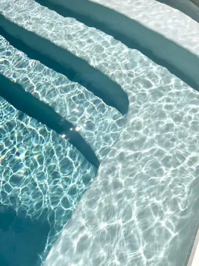 Foto detallada del color de la piscina que se oscurece a medida que el agua se hace más profunda en los escalones Ivory DiamondBrite