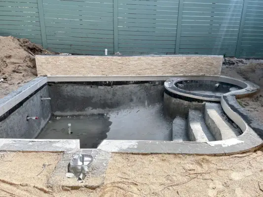 Piscine en béton avec carrelage appliqué autour de la ligne de flottaison et sur le mur de soutènement d'accent