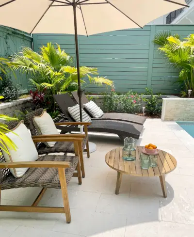 Vue latérale du coin salon avec chaises longues parasol et petite table basse