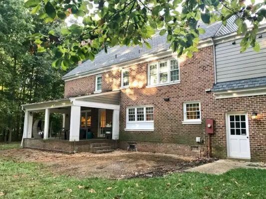 photo d'avancement d'une maison en brique avec terrasse retirée et garniture peinte en blanc