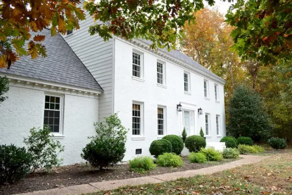 maison moderne en brique peinte en blanc avec porte bleue