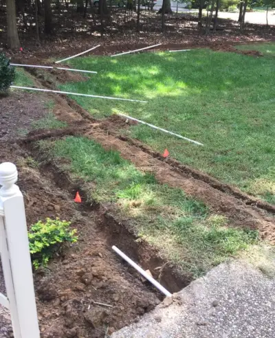 installer un système d'irrigation en posant des tuyaux en PVC le long des tranchées