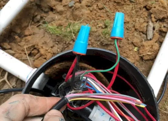 conectando fio preto e verde à válvula do sistema de irrigação