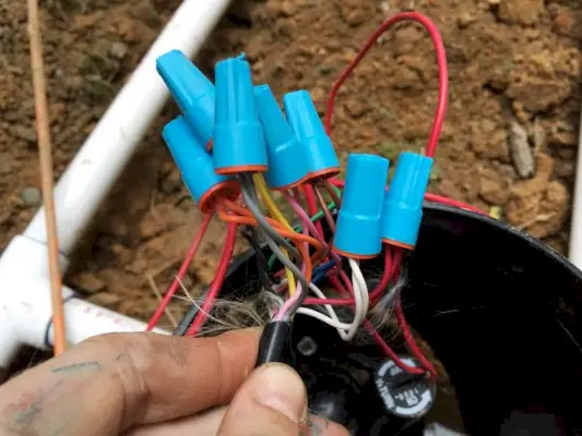 connexion des fils souterrains au boîtier de vannes pour le système d'irrigation