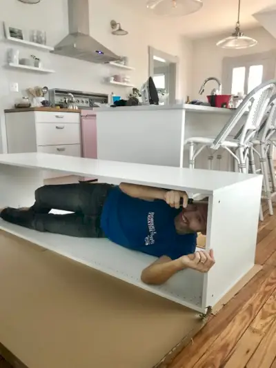 John allongé dans un meuble Ikea pendant l'assemblage