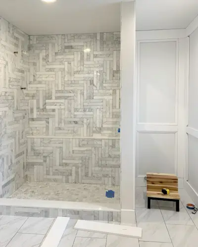 Moldura de pared decorativa sin pintar en el baño principal con ducha de mármol con azulejos