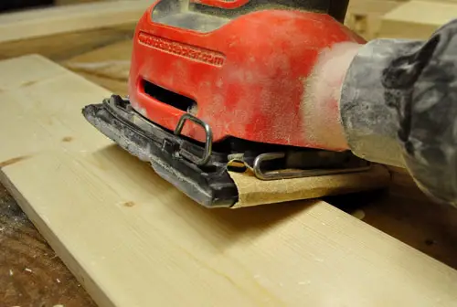 utiliser une ponceuse à paume Black & Decker pour lisser les bords d'une planche de bois