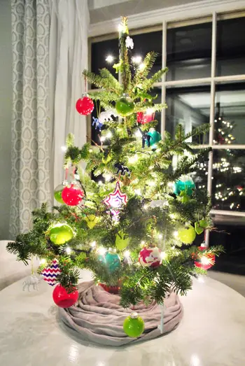 Kleine selbstgemachte Ornamente auf buntem Tisch-Weihnachtsbaum