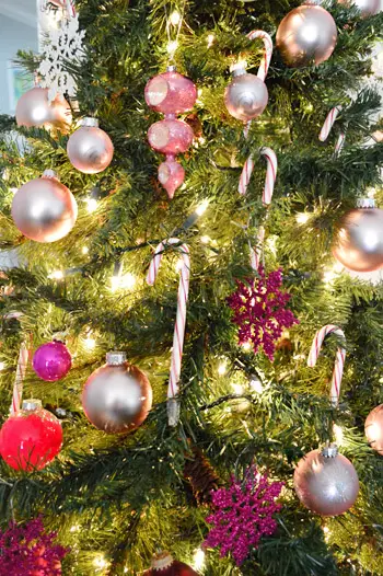 Close-up op roze en rode ornamenten en snoepstokken op de kerstboom met kleurovergang