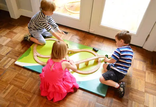 Enfants jouant avec une planche de train DIY lors d'une fête d'anniversaire