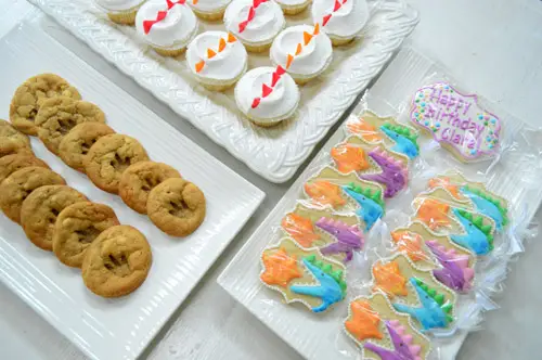 Desserts op Dragon Birthday Party met voetafdrukkoekjes Iced Cookies Cupcakes met schubben